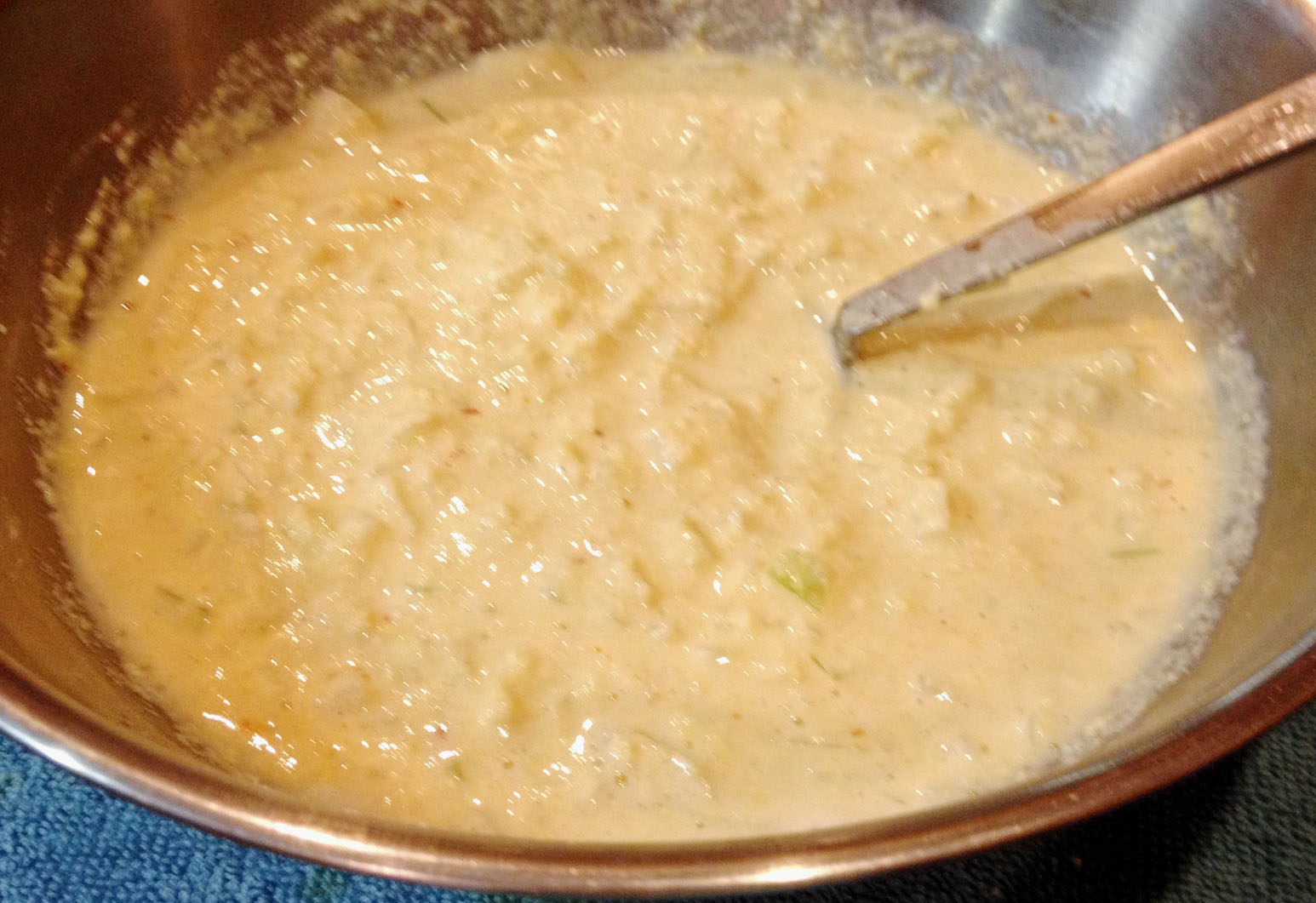 Prepared Batter with Chopped Onions with a ladle.